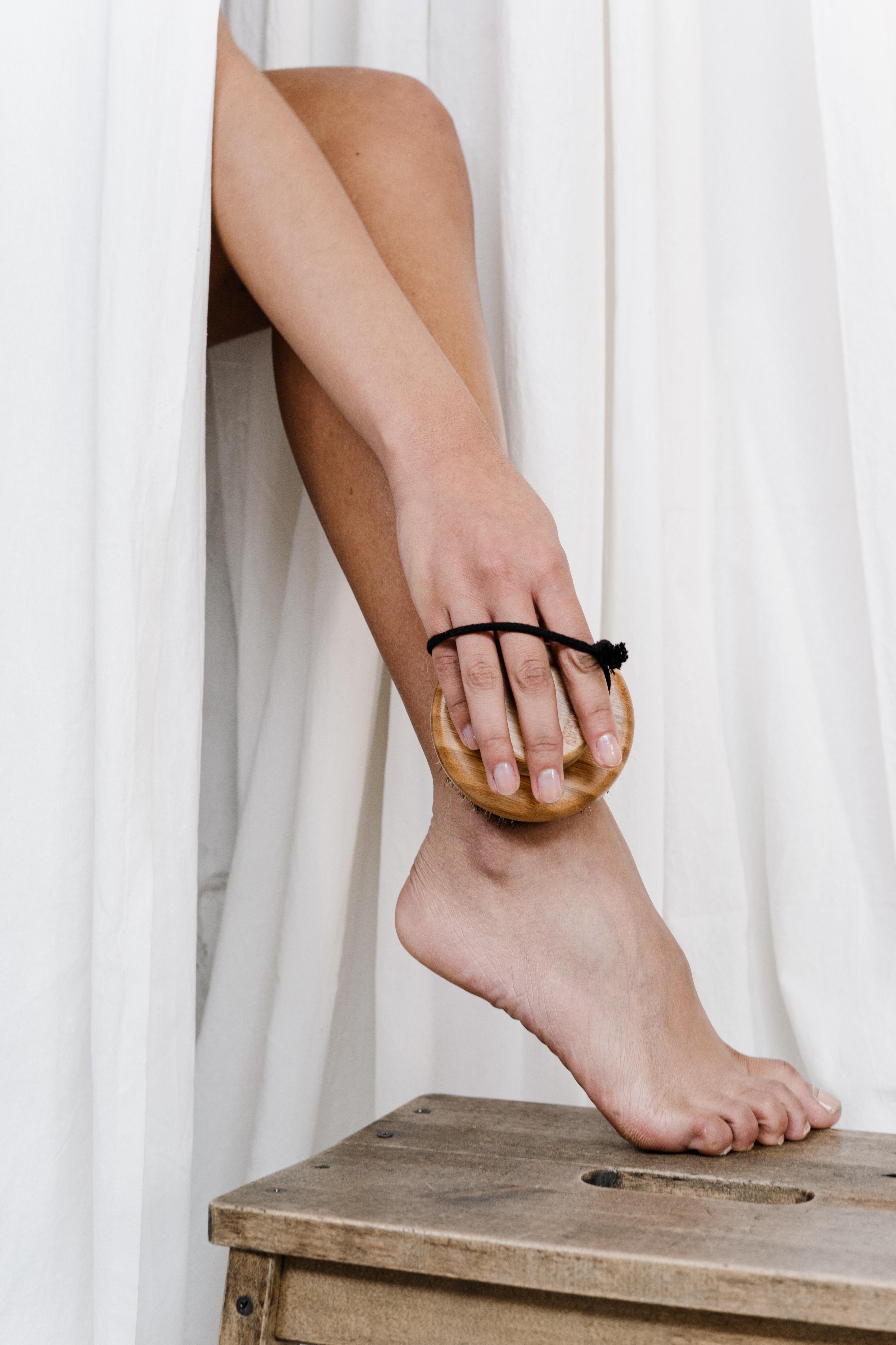 Femme se brossant la jambe avec une brosse pour le corps